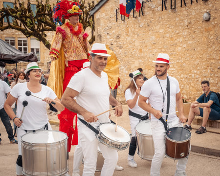 Nabirat, Nouvelle-Aquitaine, France - 12th May 2024: A drum band and stilt walker entertain the visitors at the annual strawberry fair, Foire de la Fraise, at Nabirat in the Dordogne region of Franceのeditorial素材