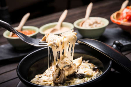 Mushroom cheese fondou with dips in backgroundの写真素材