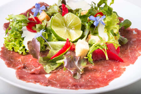 Beef Carpaccio with garnish and chili and limeの写真素材