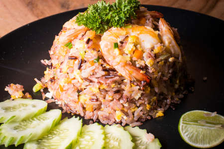 Fried rice with shrimp served with cucumber and limeの写真素材
