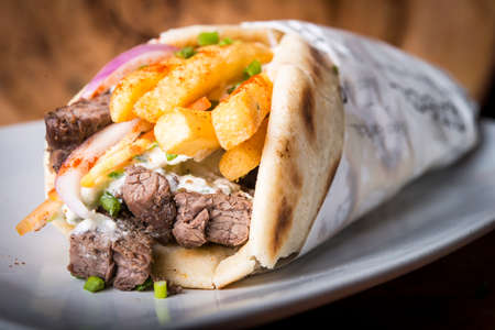 Beef gyros Greek style wrap in pita bread with french friesの写真素材