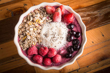 down medium shot of healthy smoothie bowl with wooden backgroundの写真素材