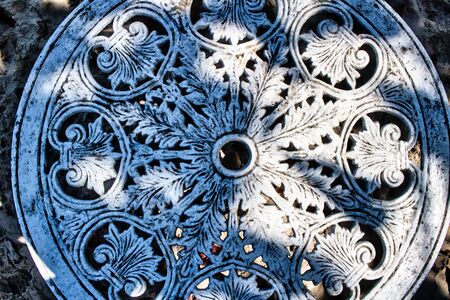 This unique photo shows an old dilapidated metal table with beautiful ornaments