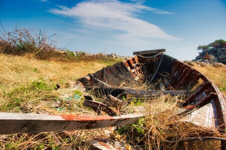 In this unique photo you can see an old broken wooden fishing boat that recovers nature!の写真素材