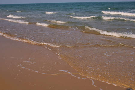 This unique photo shows the natural beach of Thailand with light waves on a windless summer midday.の写真素材
