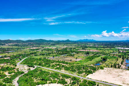 This unique photo shows the landscape of Hua Hin in Thailand and in the background the green mountains with a slightly cloudy blue skyの写真素材