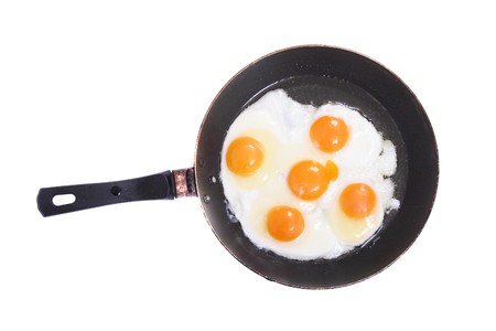 fried eggs on the pan on the whte backgroundの写真素材