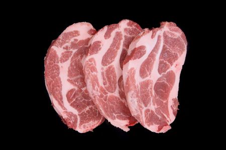 raw steaks isolated on the black background の写真素材