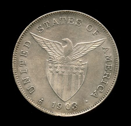 old one dollar coin isolated on the black backgroundの写真素材