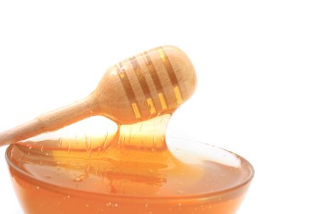 glass with honey isolated on the white backgroundの写真素材