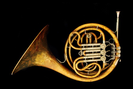 old french horn isolated on the black backgroundの写真素材