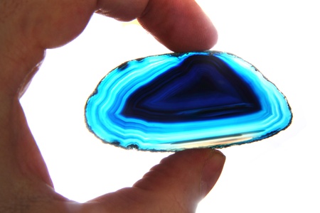 agate gem in human hand  isolated on the white background