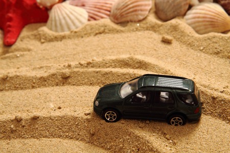small toy car in the sand as nice summer backgroundの写真素材