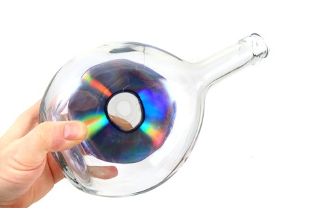 CD or DVD in the glass bottle isolated on the white background