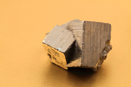 pyrite cubes isolated on the golden background