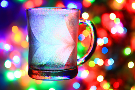 glass cup on the christmas lights backgroundの写真素材