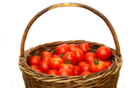 fresh tomatoes in basket isolated on the white backgroundの写真素材