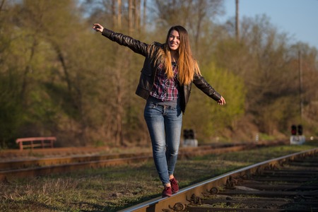 Beautiful girl walking on railroad. Photoの写真素材
