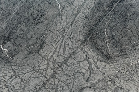 Black granite with white cracks texture abstract as background. Natural stone. Photo.