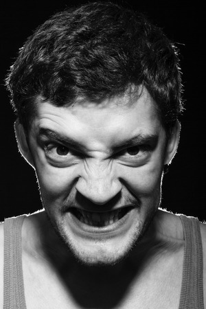 Angry upset man with scary evil face. Black and white photography.