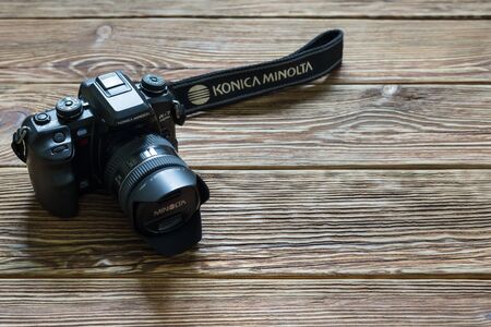 Chisinau, Republic of Moldova - March 14, 2018: dslr camera Minolta a 7 and lens on wooden background in Chisinau, Republic of Moldova. Photo.のeditorial素材
