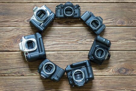 Chisinau, Republic of Moldova - March 14, 2018: different models of Canon cameras arranged in a circle. Wooden background. Horizontally framed shot.のeditorial素材