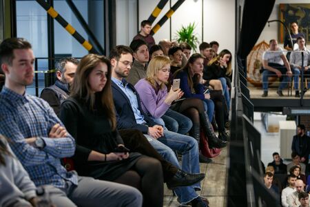 Chisinau, Republic of Moldova - March 11, 2018: audience on balcony at a business conference. A woman is recording on a smartphone. Horizontally framed shot.のeditorial素材
