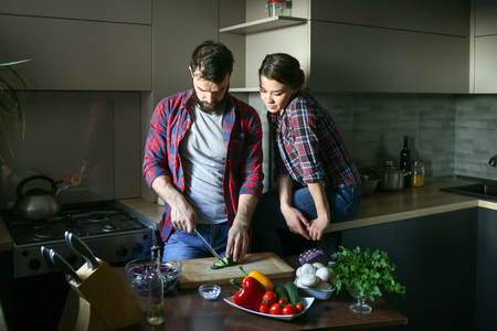 Beautiful young couple in kitchen at home while cooking healthy food.の写真素材