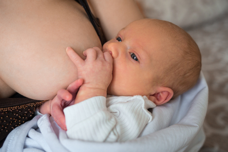Mother breast feeding and hugging her baby.の写真素材