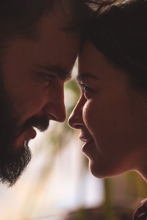Close portrait of a young couple. Man and woman in love. Cling to each other. Vertically framed...