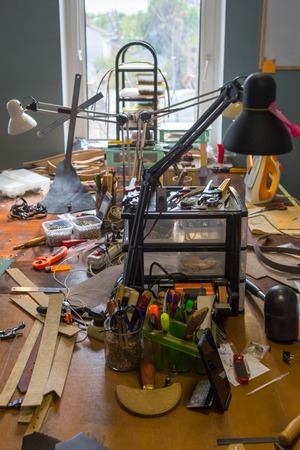 Work desk in the tannery. Handmade concept. Concept of small business to create leather products. Vertically framed shot.の写真素材