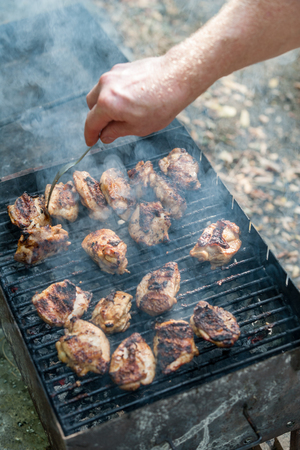 Chicken kebab prepared in a rusty brazier. In the background smoke. Vertically framed shot.の写真素材
