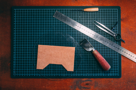 A set of tools for working with leather on a wooden table. Handmade concept. Concept of small business to create leather products. Horizontally framed shot.の写真素材
