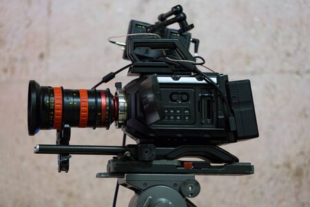 Process of filming. Big movie camera on a tripod. Horizontally framed shot.
