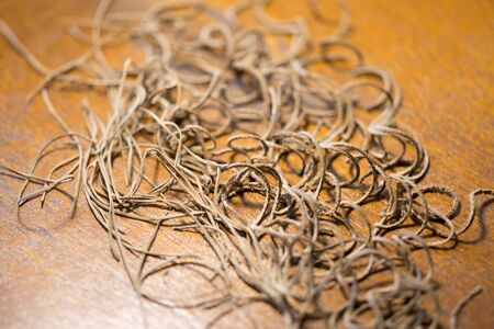 There were leather threads on the brown wooden table. Horizontally framed shot.の写真素材