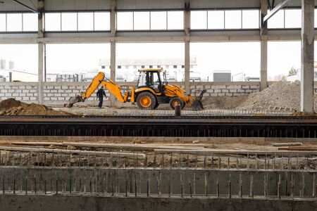 Chisinau, Republic of Moldova - February 04, 2020: Excavator and builder on the construction site....