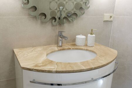 Marble sink, chrome faucet and bathroom accessories. Modern bathroom design. Horizontally framed shot.の写真素材