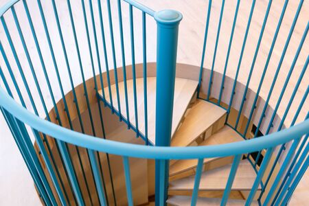 Spiral staircase, forged green handrail and wooden steps in modern home. Horizontally framed shot.の写真素材