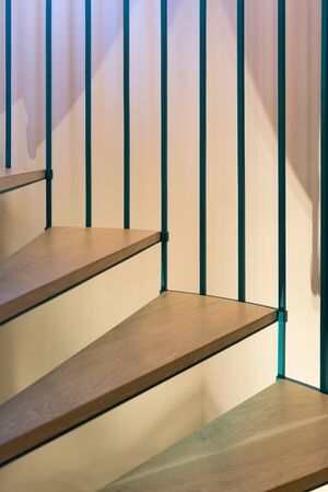 Spiral staircase, forged green handrail and wooden steps in modern home. Vertically framed shot.の写真素材