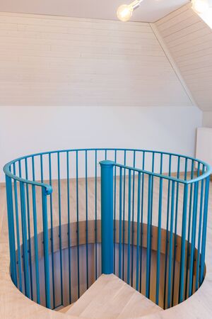Spiral staircase, forged green handrail and wooden steps in modern home. Vertically framed shot.の写真素材