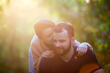 Portrait of young beautiful couple in the Park. In the background of leaves of trees and the setting sun. Horizontally framed shot.の写真素材