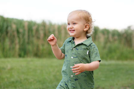 Portrait of a cute little boy on the background of reeds. Walk in park. Family life. Horizontally framed shot.の写真素材