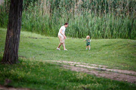 Father and son play on the lake. Walk in park. Family life. Horizontally framed shot.の写真素材