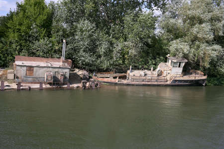 Rusty old ship on the banks of the river. Horizontally framed shot.の写真素材