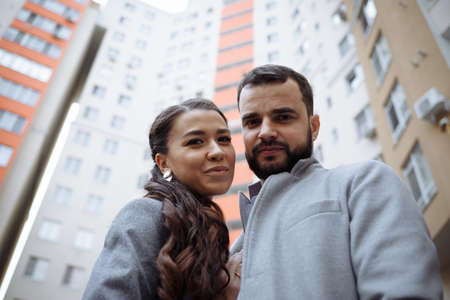 Newly married couple in front of new apartment building. Horizontally framed shot.の写真素材