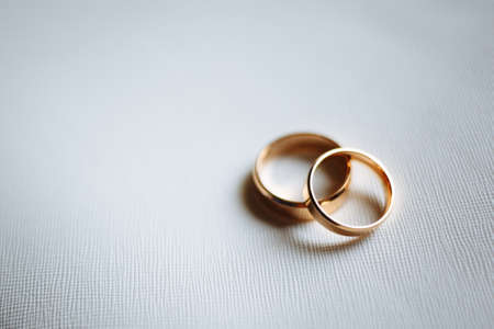Two golden wedding rings on white background. Horizontally framed shot.の写真素材