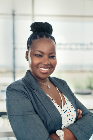 Portrait of a beautiful smiling black businesswoman with her arms crossedの写真素材