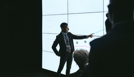 Indian businessman pointing at digital screen during a presentationの写真素材
