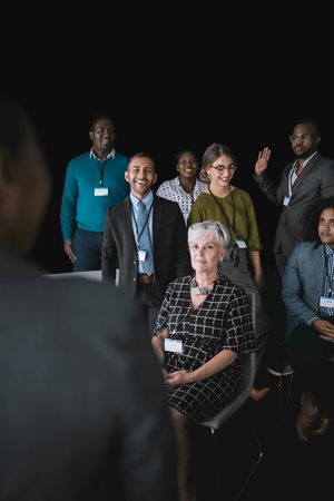 Black african businesswoman giving a presentation at a business conference. Mixed race group are interacting with herの写真素材