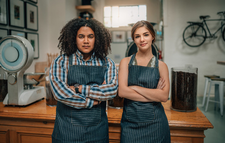 Portrait of confident baristas with arms crossed at the coffee shopの写真素材